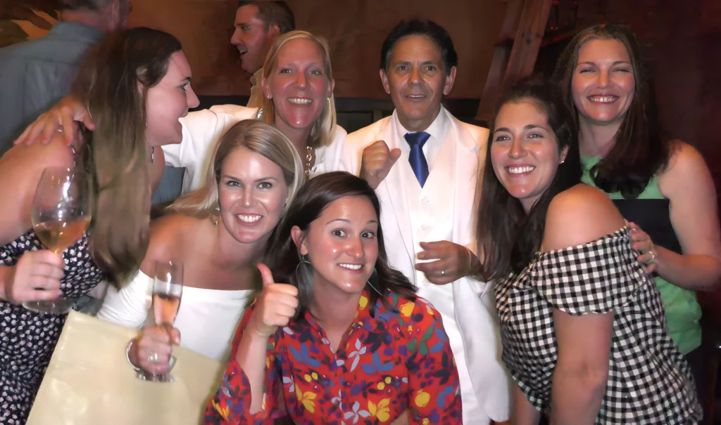 The Best in Magic Entertainment Image of Boston Magician Joe Ferranti posing for a picture with smiling young ladies who enjoyed his Close Up Magic