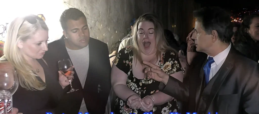 Close-up magician amazing a group of guests with interactive magic at a live event