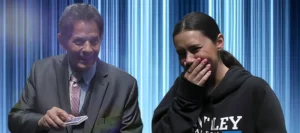 Close-up magician performing card magic as a guest reacts with laughter and surprise